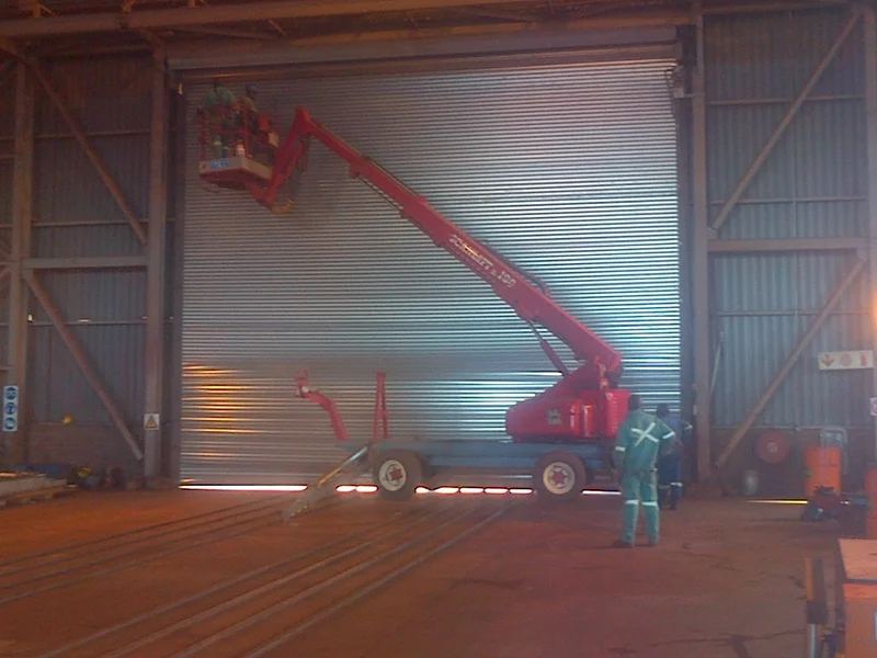 Technicians on a cherry picker fitting a 10 500 × 8 500 mm warehouse roller door